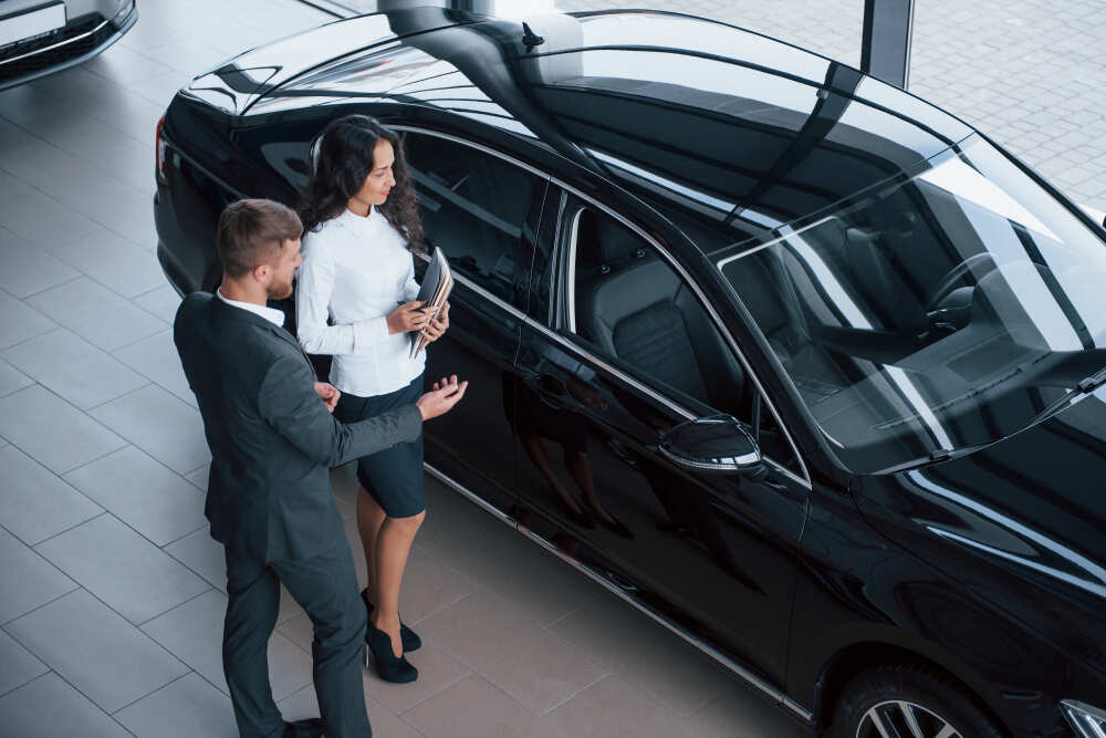 Chauffeur professionnel ouvrant la porte d'une voiture de luxe avec Top Reserve.